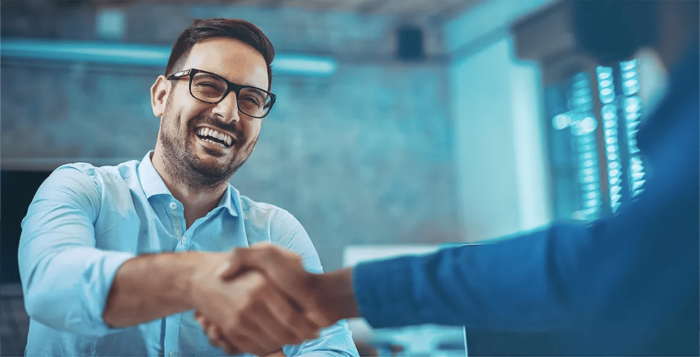 A young man thanks him with a handshake for his certified translation.