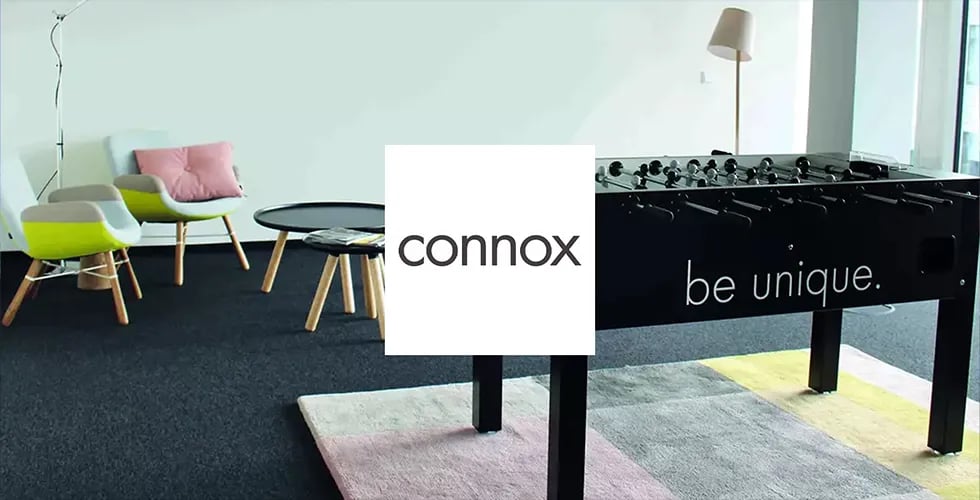 Das Logo von connox vor einem mit connox-Möbeln eingerichteten Raum.