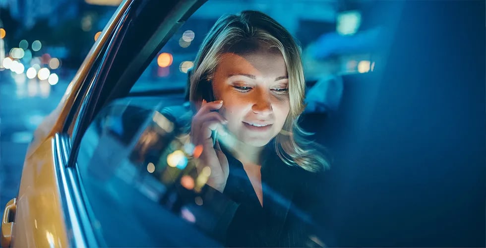 A young question sits in a taxi and orders an express translation by phone.