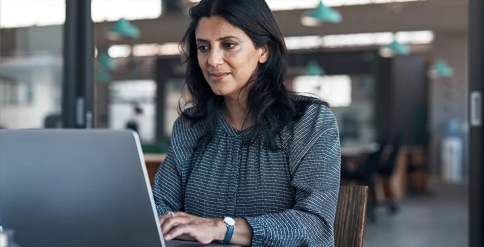 A woman sits in front of her laptop and creates a glossary for a translation.