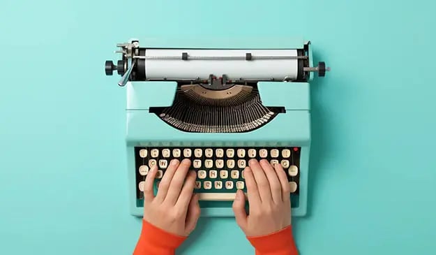 Hands writing abbreviations on an old-fashioned type writer