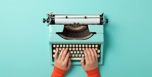 Zwei Hände tippen auf einer alten Schreibmaschine Englische Abkürzungen