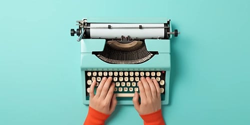 Zwei Hände tippen auf einer alten Schreibmaschine Englische Abkürzungen