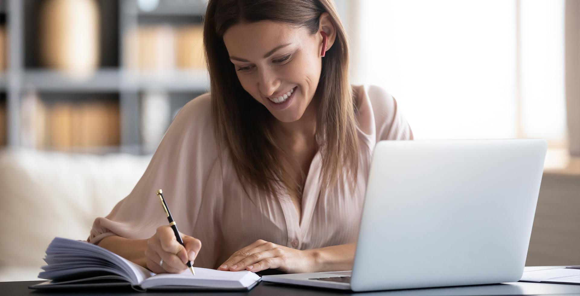 Lächelnde Junge Frau am Laptop, die eine Sprache lernt
