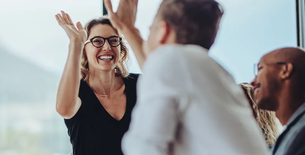 Two colleagues high-five each other - tolingo is in the Top 100 Language Service Providers 2022!