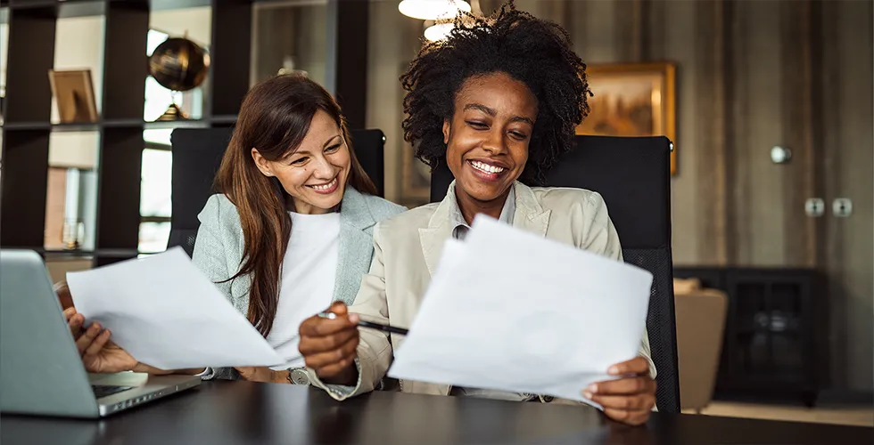 Two businesswomen are happy about the professional translations of their documents.