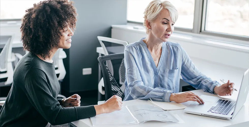 Two women look at a laptop and check their DSGVO translation