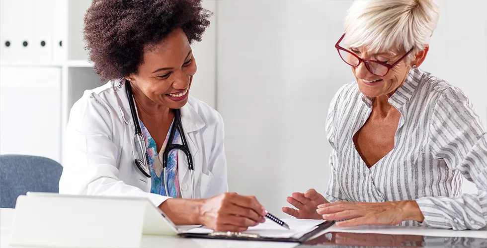 Eine Ärztin bespricht mit einer Patientin die medizinische Übersetzung ihrer Unterlagen.