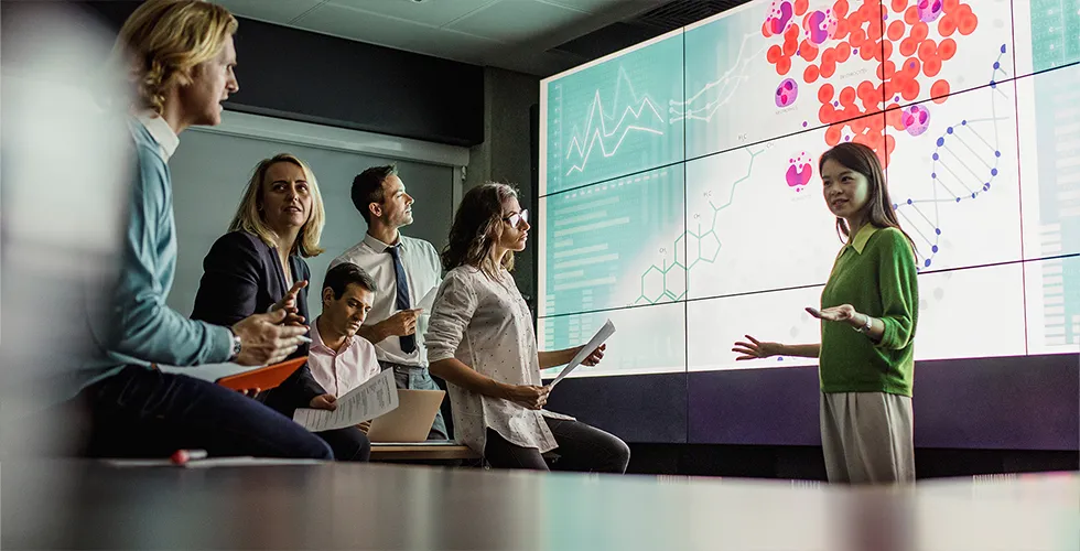 A group of scientists listens to an international lecture, with translated scientific documents in their hands.