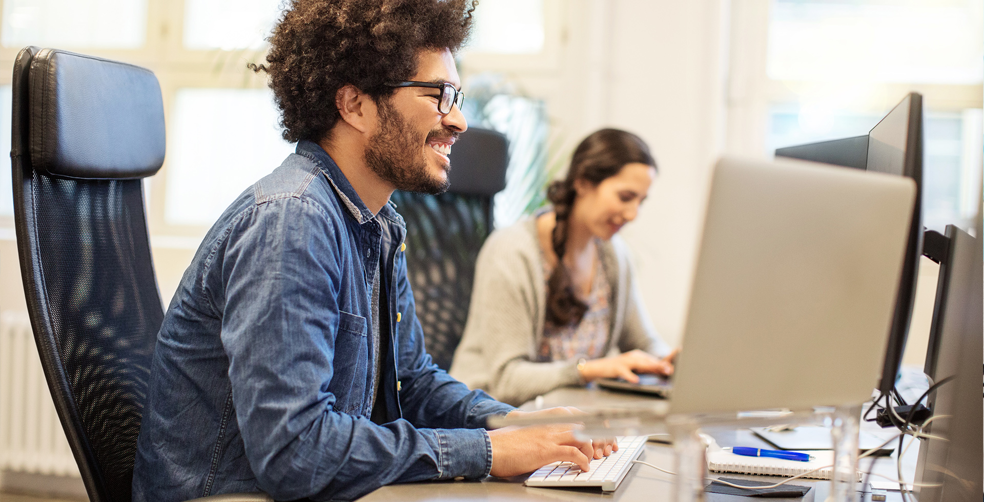 Lächelnder junger Mann am Desktop, der eine WordPress-Exportanleitung liest